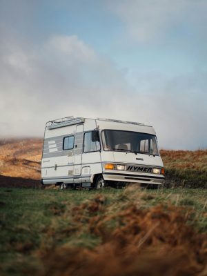 A solitary camper van parked in the scenic countryside of Lairg, Scotland.
