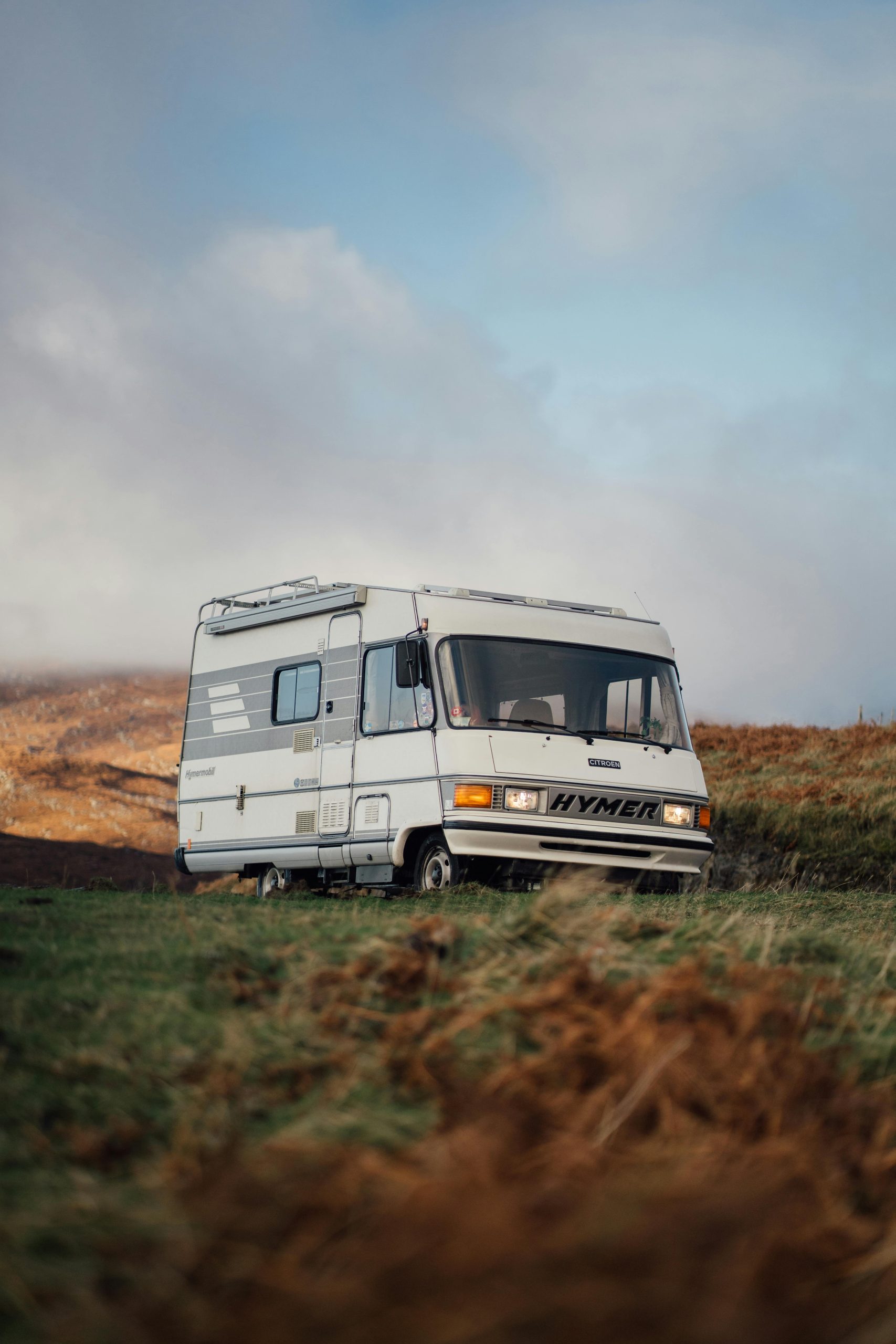 A solitary camper van parked in the scenic countryside of Lairg, Scotland.