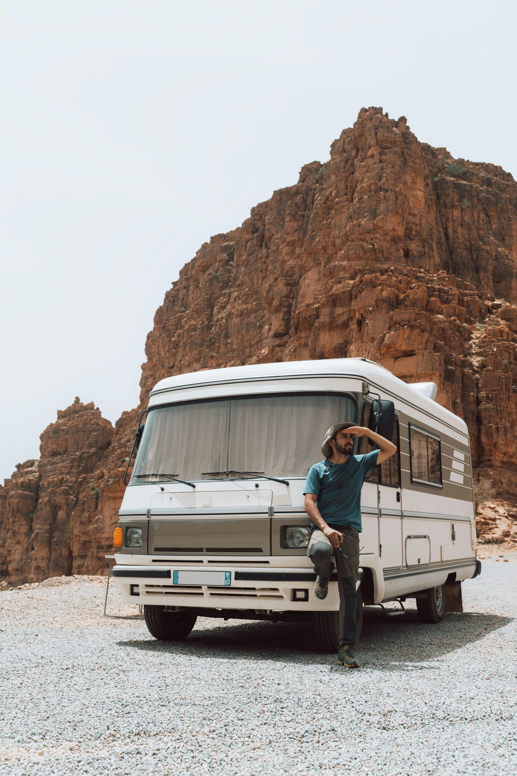 Man standing by a camper against stunning eroded rock formations. Perfect for travel and adventure themes.